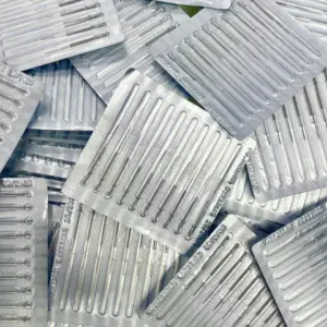 Múltiples blisters transparentes con repuestos metálicos para cauterizador dermatológico en disposición diagonal.